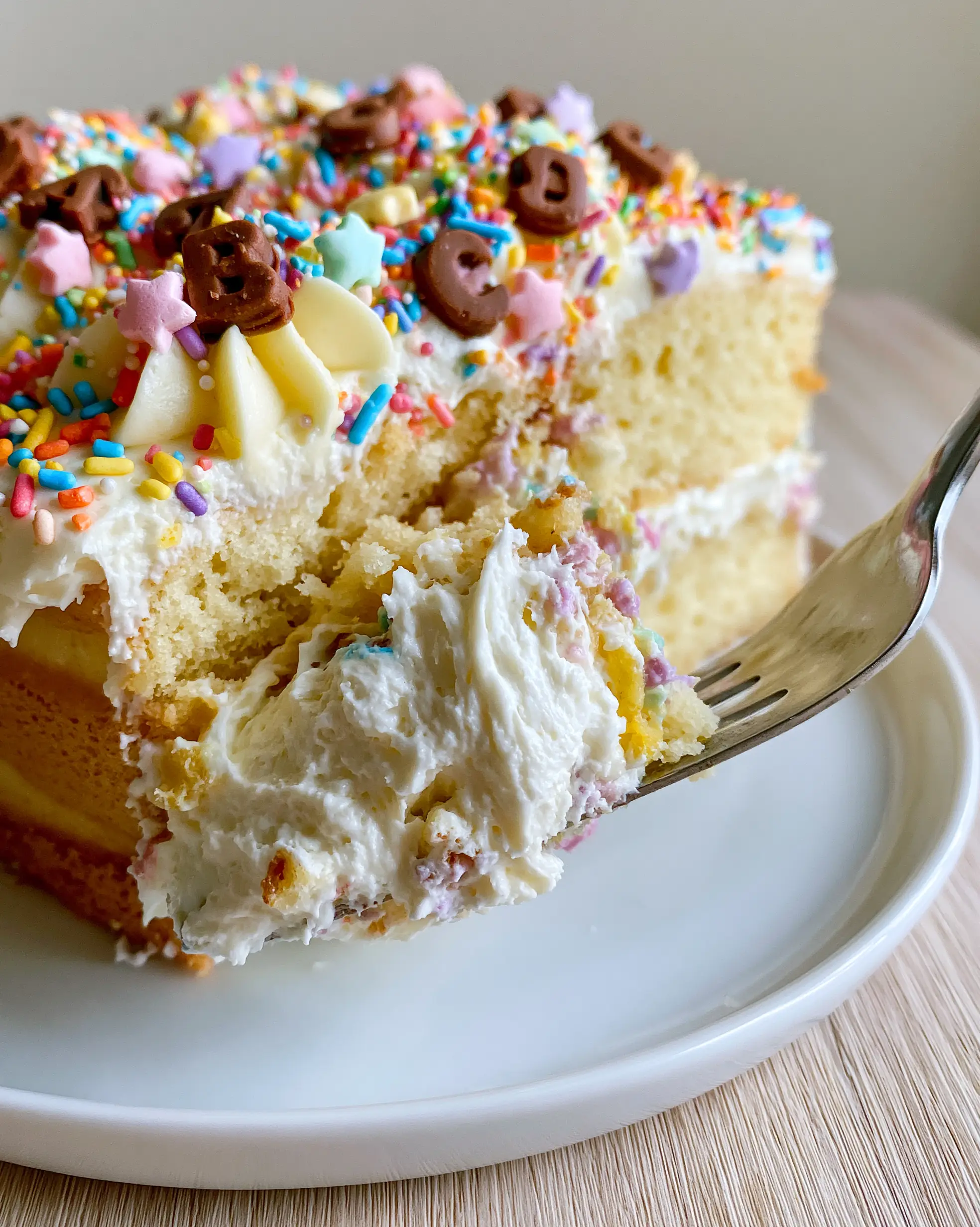 Einschulungskuchen: The Ultimate Back-to-School Vanilla Layer Cake 3 Lifting a slice of Einschulungskuchen with a silver cake server showing the whipped cream filling.